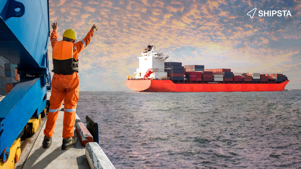 Man at dock celebrating a shipping container leaving port. 